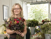 Blumenverkäuferin mit Blumenstrauß in der Hand.